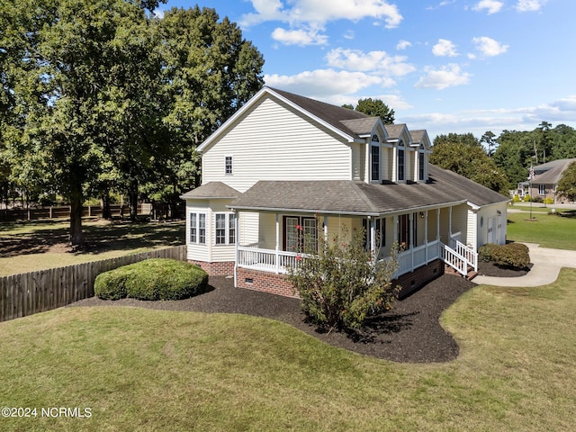 view of side of property featuring a lawn and covered porch