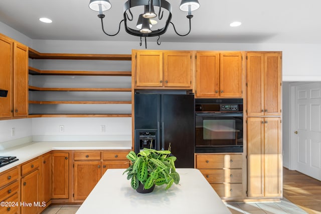 kitchen featuring a chandelier, black appliances, and light wood-type flooring