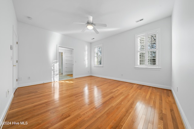 empty room with ceiling fan and light hardwood / wood-style floors