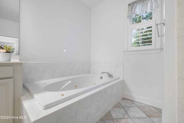 bathroom featuring tile patterned floors and a relaxing tiled tub