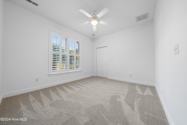 empty room featuring carpet flooring and ceiling fan