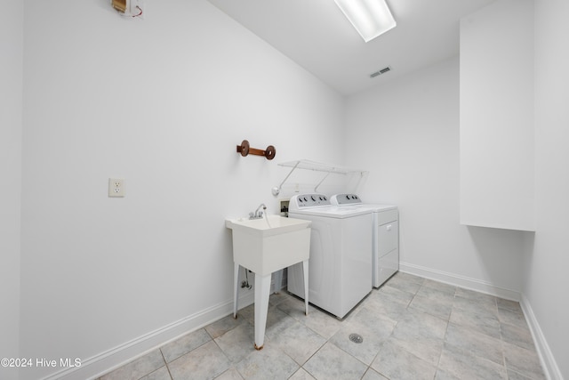 washroom featuring light tile patterned floors and washer and clothes dryer