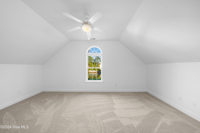 additional living space featuring ceiling fan, lofted ceiling, and light carpet