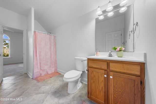 bathroom featuring tile patterned floors, vanity, toilet, and vaulted ceiling