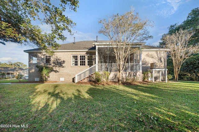 back of property featuring a yard and a sunroom