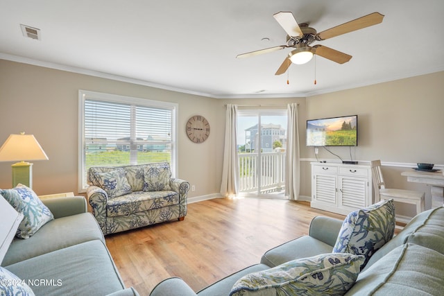 living room featuring light hardwood / wood-style flooring, ceiling fan, a healthy amount of sunlight, and crown molding