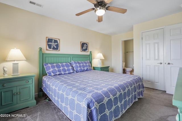 bedroom featuring dark colored carpet, ceiling fan, ensuite bathroom, and a closet