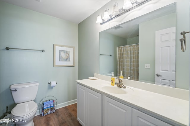 bathroom featuring walk in shower, toilet, vanity, and hardwood / wood-style flooring