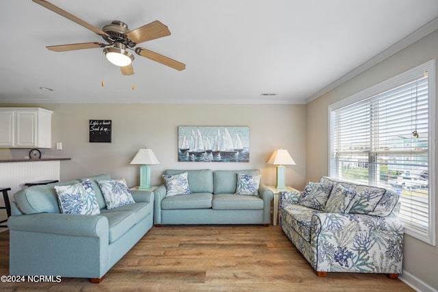 living room with ceiling fan, light wood-type flooring, and ornamental molding