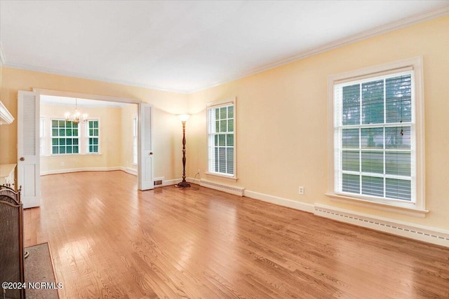 unfurnished living room with a chandelier, light hardwood / wood-style floors, and plenty of natural light