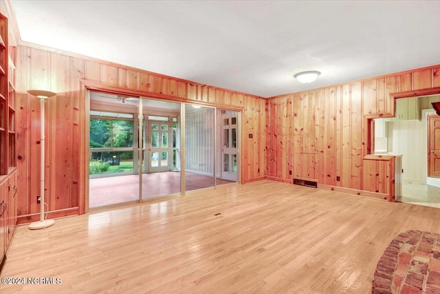 empty room featuring wooden walls and light hardwood / wood-style flooring