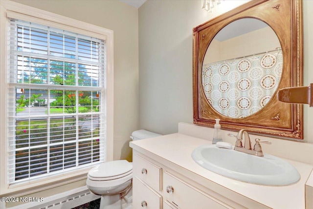 bathroom with a healthy amount of sunlight, a baseboard radiator, vanity, and toilet