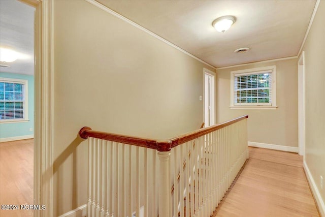 corridor featuring light wood-type flooring and crown molding