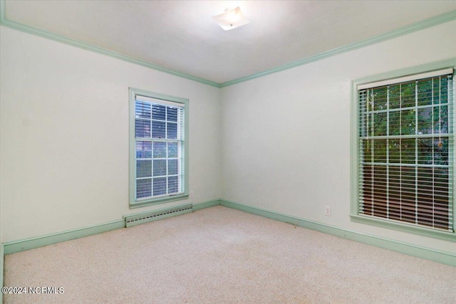 empty room featuring carpet floors, ornamental molding, and a baseboard heating unit