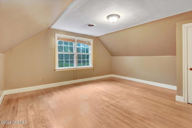 bonus room with light wood-type flooring and lofted ceiling