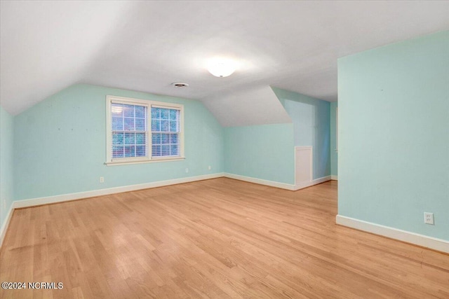 additional living space with lofted ceiling and light hardwood / wood-style floors