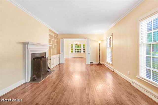 unfurnished living room with a baseboard heating unit, wood-type flooring, a notable chandelier, built in shelves, and crown molding