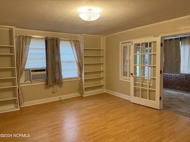 unfurnished room with cooling unit, crown molding, and wood-type flooring