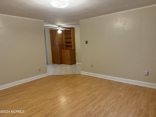 spare room featuring light wood-type flooring, ceiling fan, and crown molding