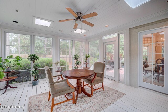 sunroom / solarium with crown molding, wood-type flooring, a skylight, and wooden ceiling
