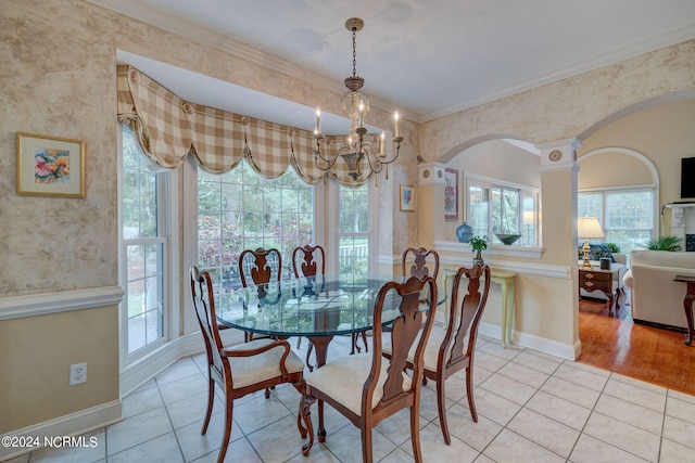 dining area featuring light wood-type flooring, crown molding, and a notable chandelier