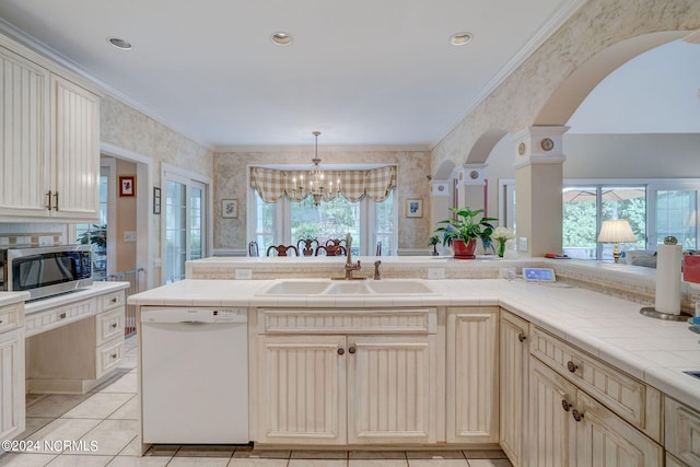 kitchen with an inviting chandelier, a wealth of natural light, dishwasher, and tile countertops