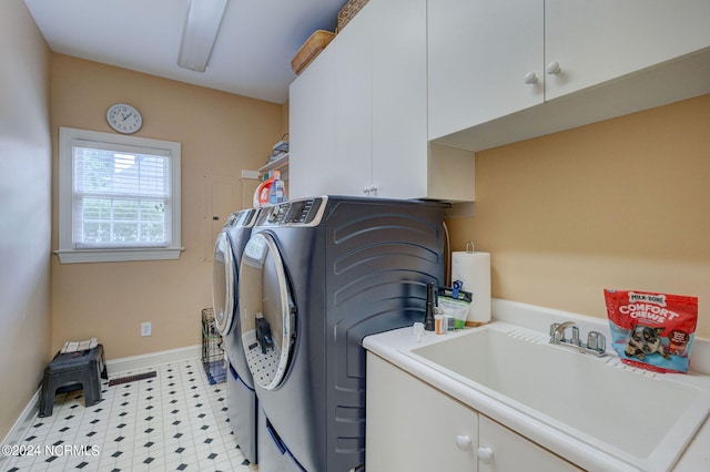 washroom featuring cabinets, washer and clothes dryer, and sink