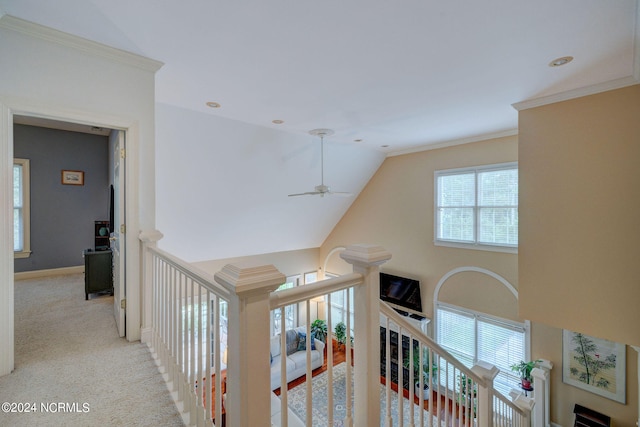 hall featuring ornamental molding, vaulted ceiling, and light colored carpet