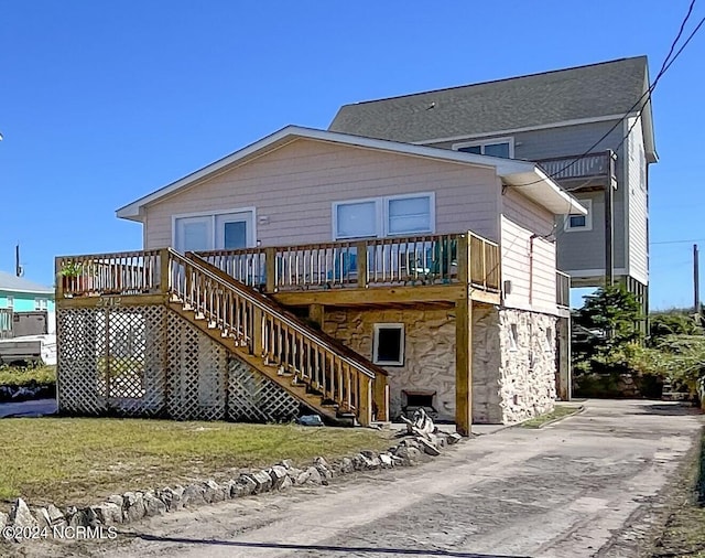 2712 Island Dr, North Topsail Beach, NC 28460 - rear view of house with a yard, a wooden deck, stone siding, and stairs