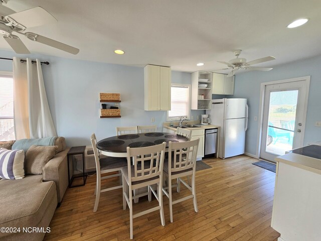 dining room featuring sink, light wood-type flooring, and ceiling fan