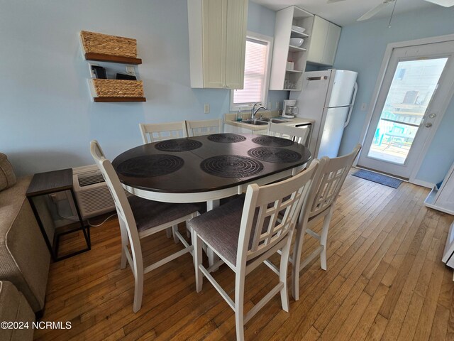 dining room with ceiling fan, sink, and light hardwood / wood-style floors