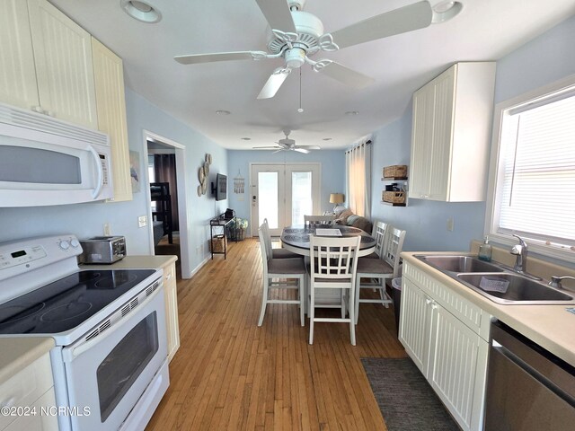 kitchen with ceiling fan, sink, white appliances, light hardwood / wood-style flooring, and white cabinetry