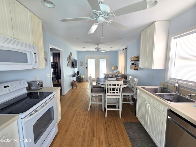 2712 Island Dr, North Topsail Beach, NC 28460 - kitchen with a sink, light countertops, white appliances, and light wood-style floors