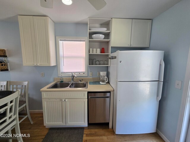 kitchen featuring wood-type flooring, white refrigerator, sink, and stainless steel dishwasher