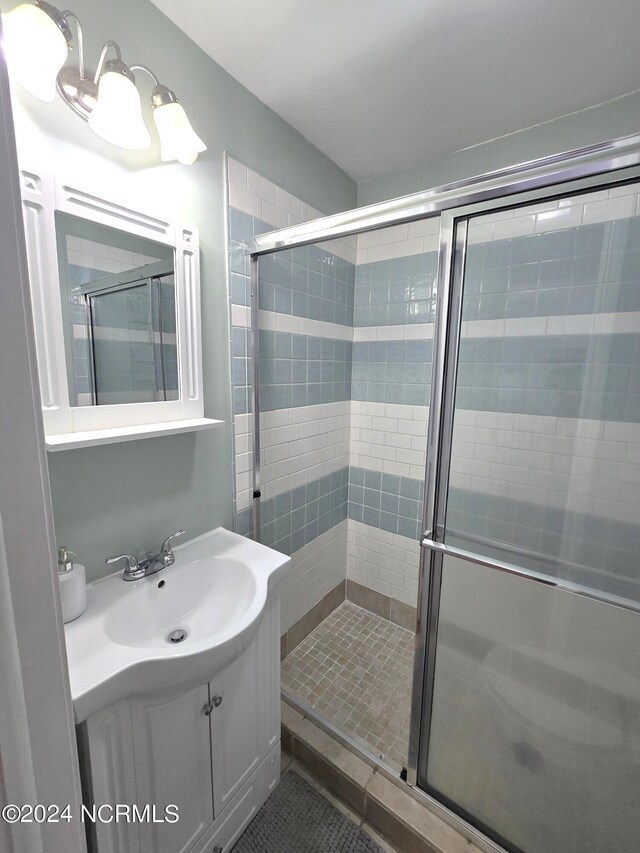 bathroom with vanity, an enclosed shower, and tile patterned floors