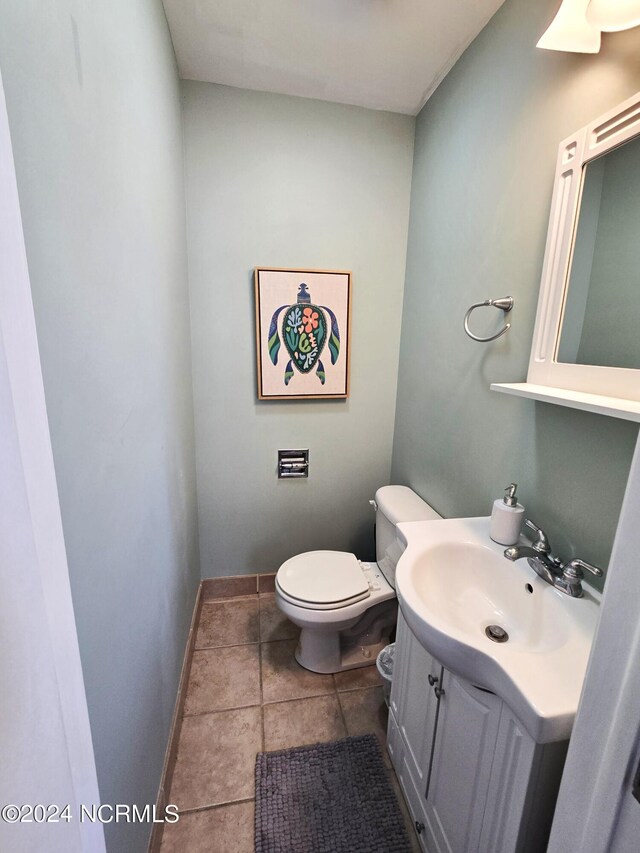 bathroom with tile patterned flooring, vanity, and toilet