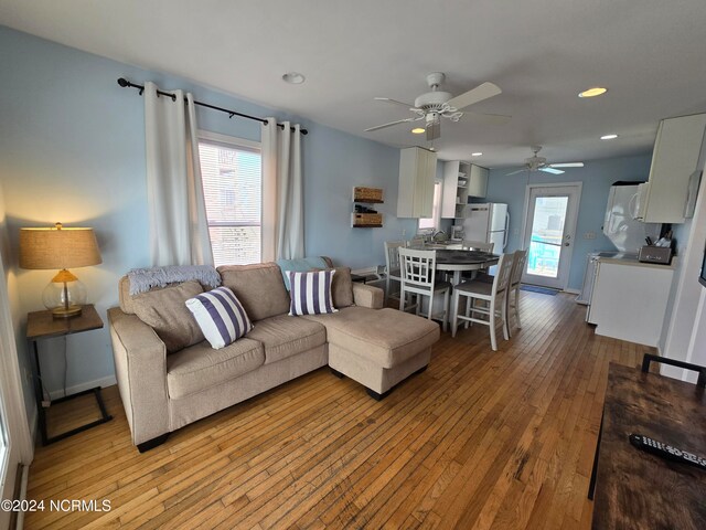 living room with light hardwood / wood-style flooring and ceiling fan