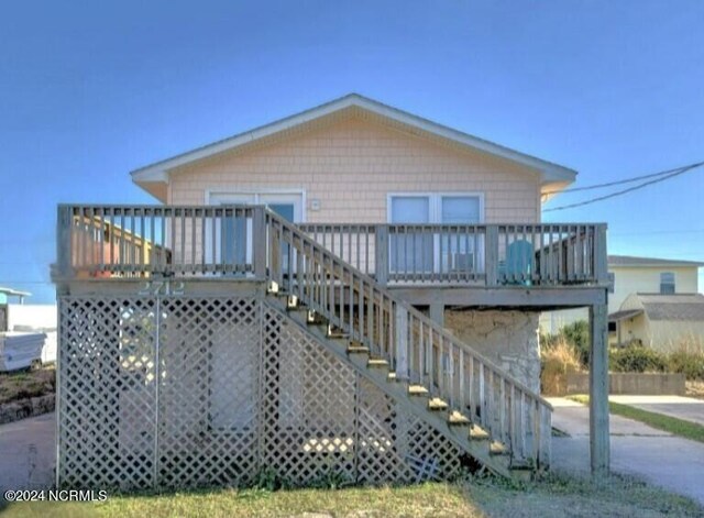 rear view of property featuring a wooden deck