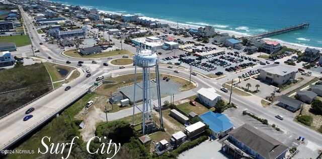 birds eye view of property with a water view and a beach view