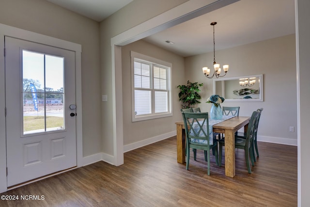 dining space with hardwood / wood-style floors, a notable chandelier, and plenty of natural light