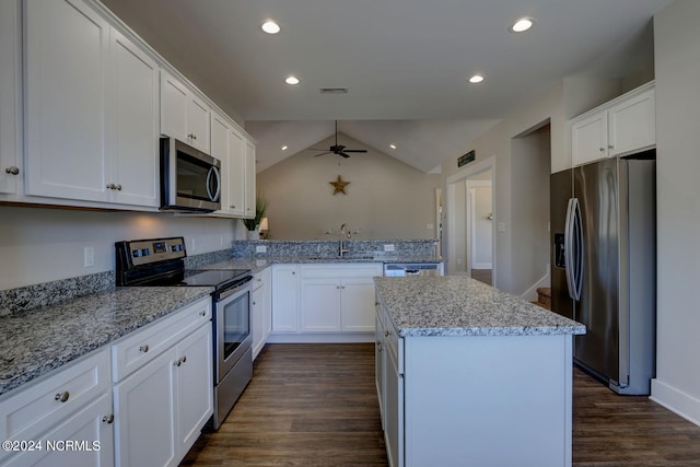 kitchen featuring sink, light stone counters, a kitchen island, stainless steel appliances, and white cabinets