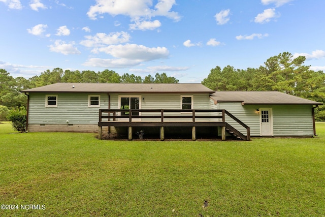 back of property with a lawn and a deck