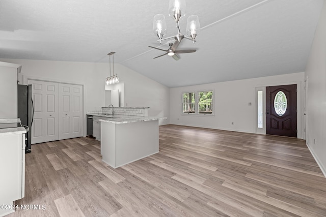 kitchen with light wood-type flooring, ceiling fan with notable chandelier, white cabinetry, and pendant lighting