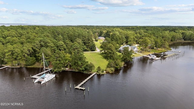 drone / aerial view with a wooded view and a water view