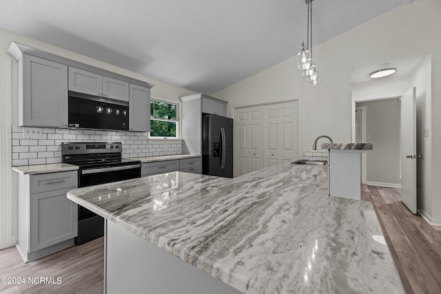 kitchen featuring gray cabinets, black fridge, range with electric cooktop, and sink