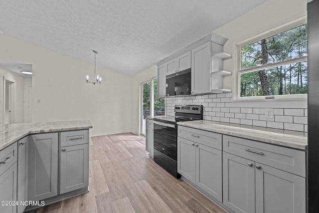 kitchen featuring electric range, gray cabinets, and a wealth of natural light