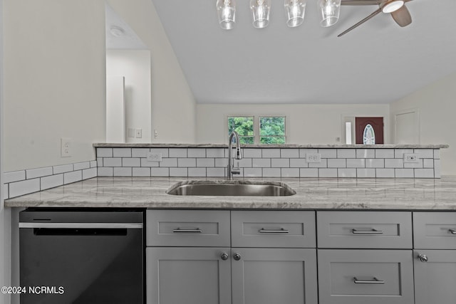 kitchen with ceiling fan, light stone counters, sink, stainless steel dishwasher, and gray cabinets