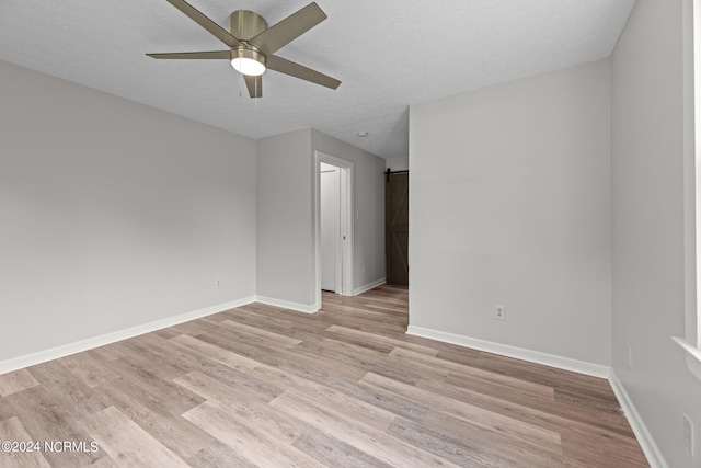 unfurnished room with light wood-type flooring, a textured ceiling, and ceiling fan