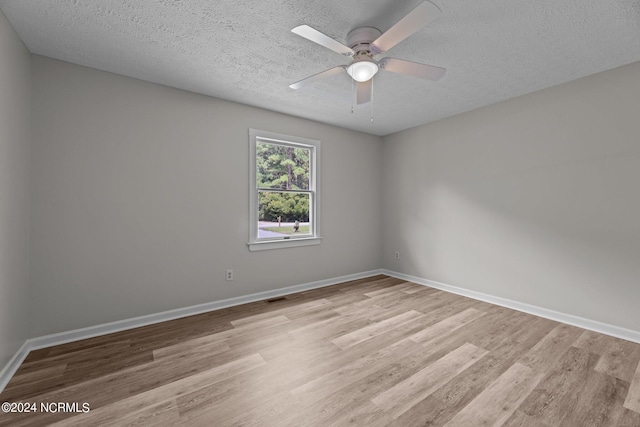 empty room with ceiling fan, a textured ceiling, and light hardwood / wood-style floors