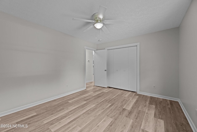 unfurnished bedroom with a closet, light wood-type flooring, ceiling fan, and a textured ceiling